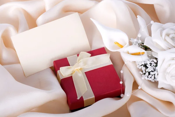 Праздничный подарок с букетом невесты и открыткой на нежной — стоковое фото