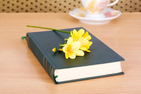 Stängd bok att läsa med en gul freesia — Stockfoto