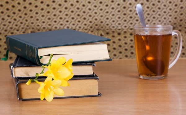 Livres à lire et une tasse de thé avec une fleur — Photo
