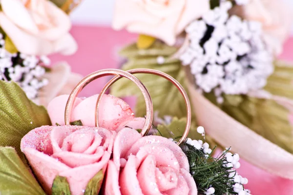 Dois anéis de casamento dourados em flores macro tiro — Fotografia de Stock