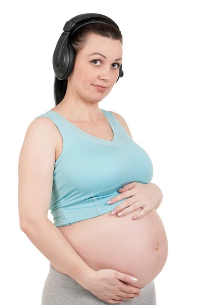 Gravid mage med hörlurar — Stockfoto