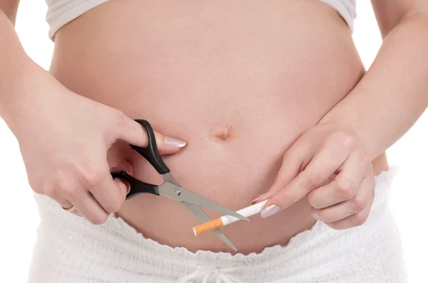 Беременный живот с сигаретами — стоковое фото