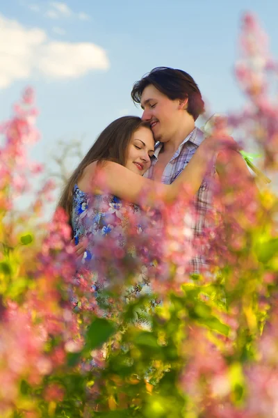 Happy νεαρό ζευγάρι στον κήπο των λουλουδιών — Φωτογραφία Αρχείου