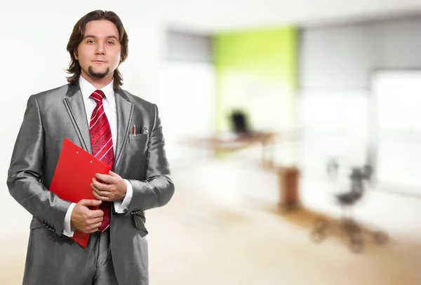 オフィスでの赤いクリップボードを持ったビジネスマン — ストック写真