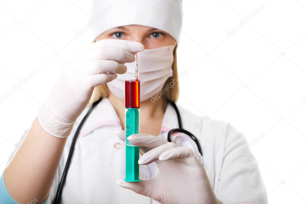 Female doctor in a mask and a syringe in hands