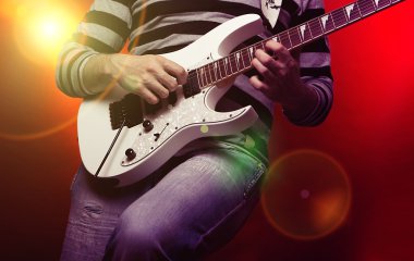 Young male musician with a white guitar clipart