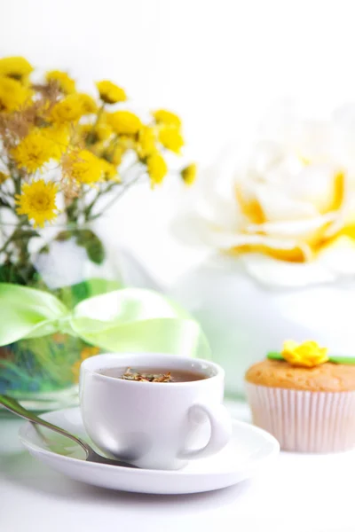 Завтрак с чаем, тортом и желтыми цветами — стоковое фото