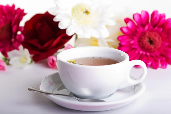 Kopp te med blomma på bordet — Stockfoto