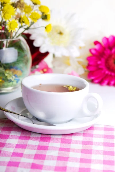 Xícara de chá com flor na mesa — Fotografia de Stock