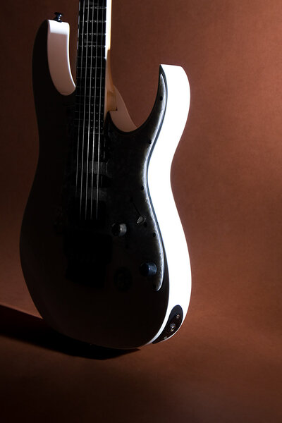 White Electric Guitar is on a brown background