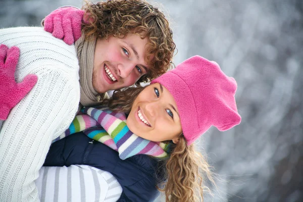 Joven pareja juguetona tiene un divertido invierno en un parque de nieve —  Fotos de Stock