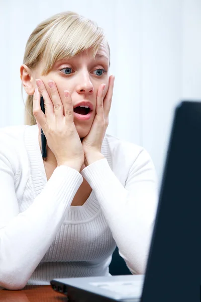 Genç bir beyaz kadın iş yerinde bilgisayar şaşırdı — Stok fotoğraf