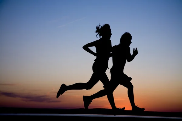 年轻夫妇一起奔跑在日落 — 图库照片