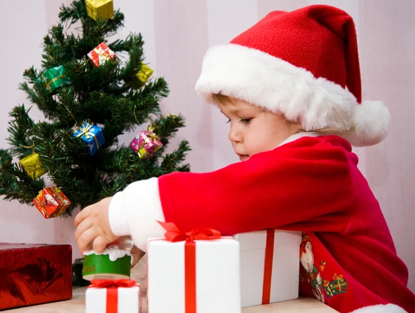 A pequena criança pressiona-se um belo presente — Fotografia de Stock
