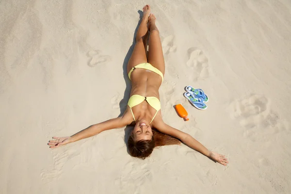 Νεαρή γυναίκα στο μπικίνι ηλιοθεραπεία στην παραλία — Φωτογραφία Αρχείου