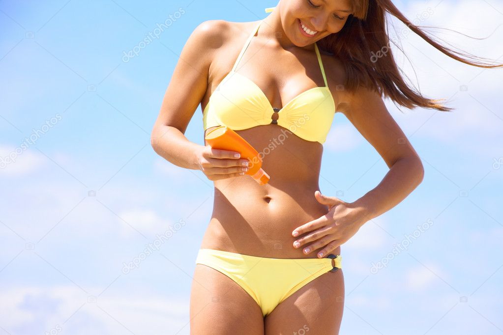 Woman in bikini smear protective cream
