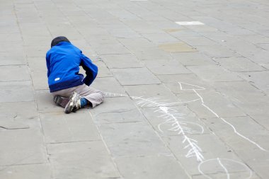 Child drawing in the street clipart