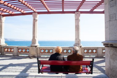 Elders sitting on a bench clipart
