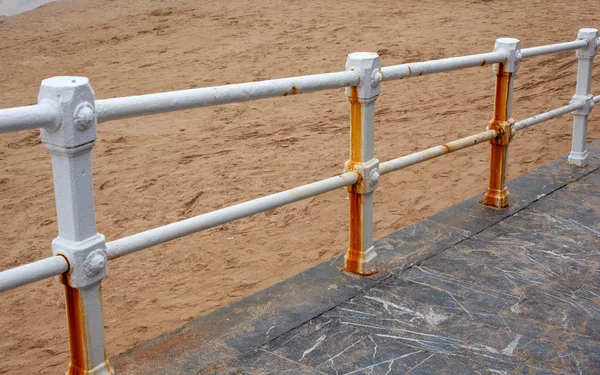 Rusty railing on the beach — Stock Photo, Image