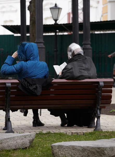 Ženy čtení na lavičce — Stock fotografie