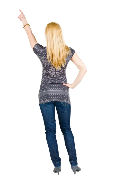 Back view of young brunette woman pointing at wall — Stock Photo, Image