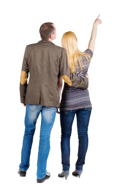 Back view of young couple pointing at wall. — Stock Photo, Image