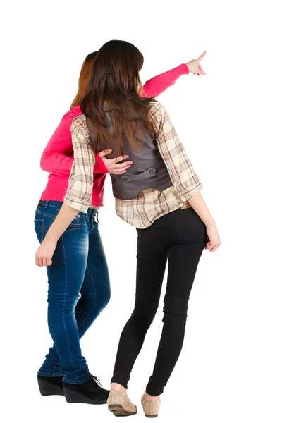 Back view of two young woman pointing at wall . — Stock Photo, Image