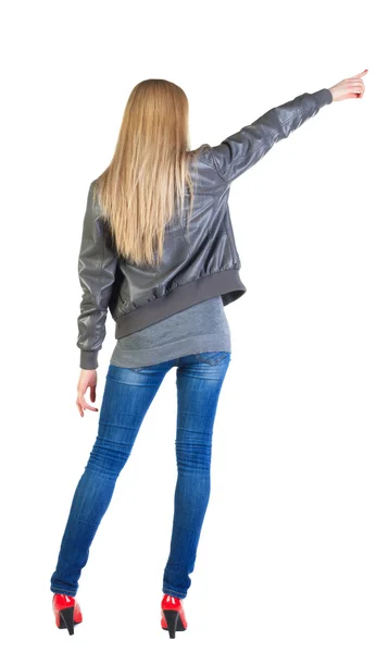 Back view of young blonde woman pointing at wall — Stock Photo, Image