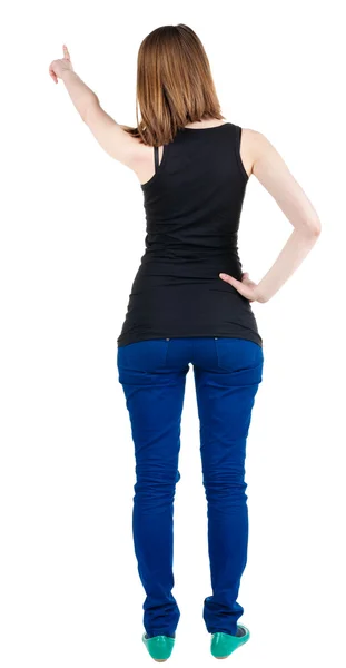 Back view of young brunette woman pointing at wal — Stock Photo, Image