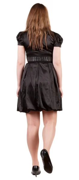 Bakifrån av pågående brunett kvinna i svart klänning. — Stockfoto