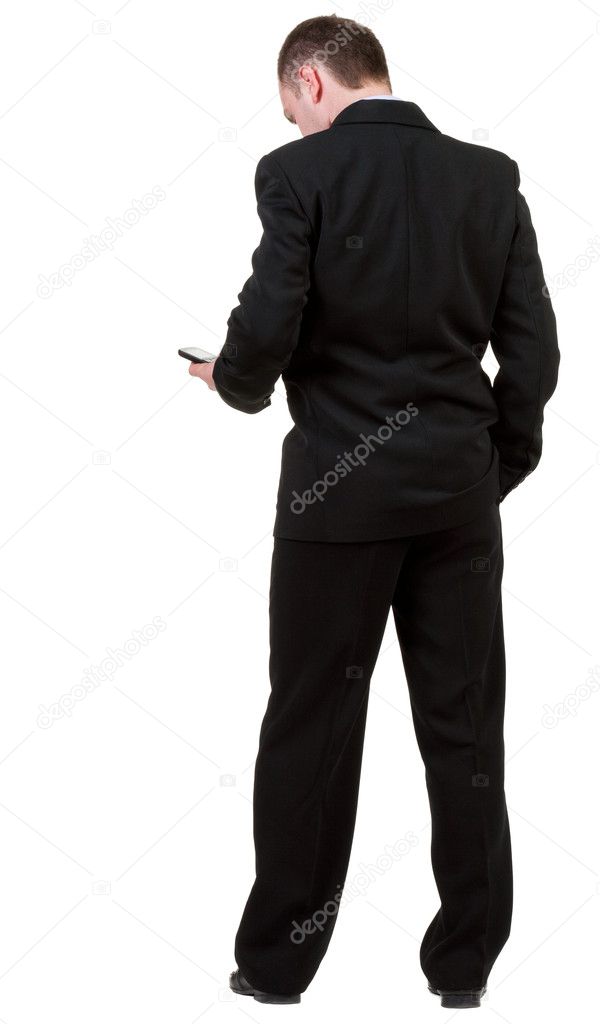 Rear view of business man in black suit talking on mobile phon