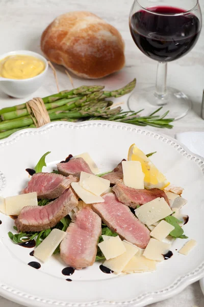 Говядина с салатом из рукколы и пармезаном — стоковое фото