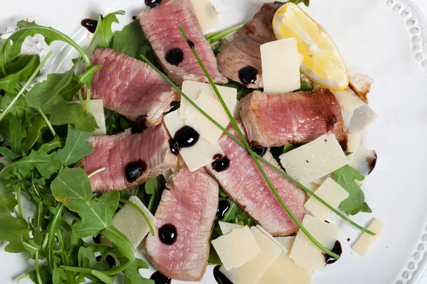 Rundvlees op rucola salade en Parmezaanse kaas — Stockfoto