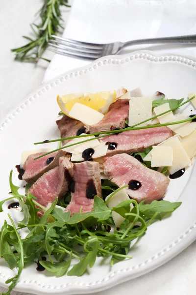 Beef on arugula salad and parmesan — Stock Photo, Image