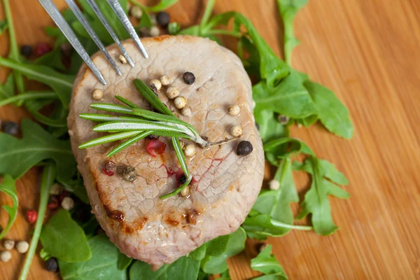 Pedaço de carne cozido em salada de arugula — Fotografia de Stock