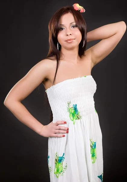 Joven chica atractiva en un vestido elegante y con una flor en h —  Fotos de Stock