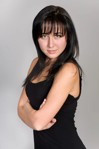 Portrét atraktivní brunetka s šedým pozadím — Stock fotografie