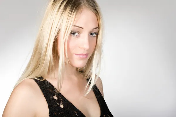 Portrét mladé blondýny na šedém pozadí — Stock fotografie