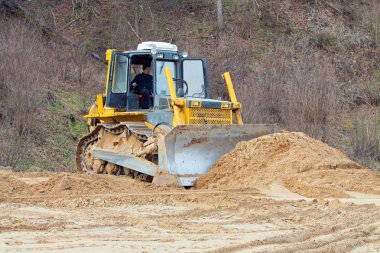 A yellow bulldozer working clipart