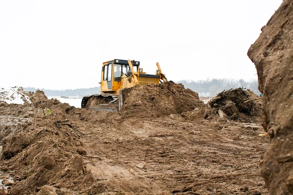 Una excavadora amarilla trabajando — Foto de Stock