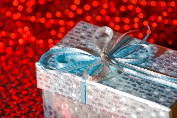 stock image The gift decorated with tape on red background.