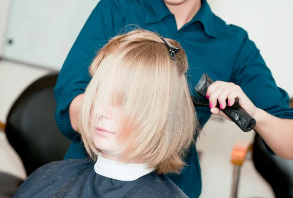 Hands of the hairdresser doing a hairdress to the girl by means — Stock Photo, Image