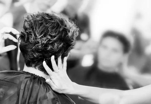 Руки парикмахера делают девушке прическу с помощью — стоковое фото