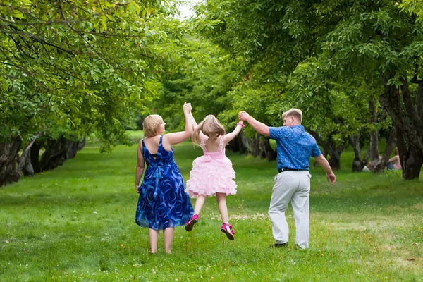 Família feliz na natureza em uma grama verde — Fotografia de Stock