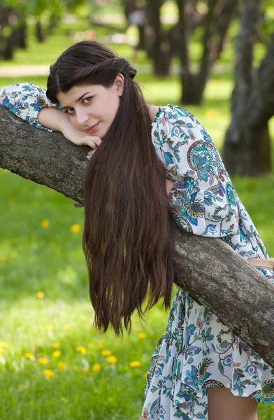 A menina de cabelos longos contra macieiras florescentes . — Fotografia de Stock