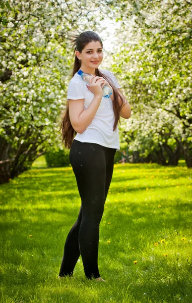 Długowłosy dziewczynę przed kwitnących jabłoni. — Zdjęcie stockowe