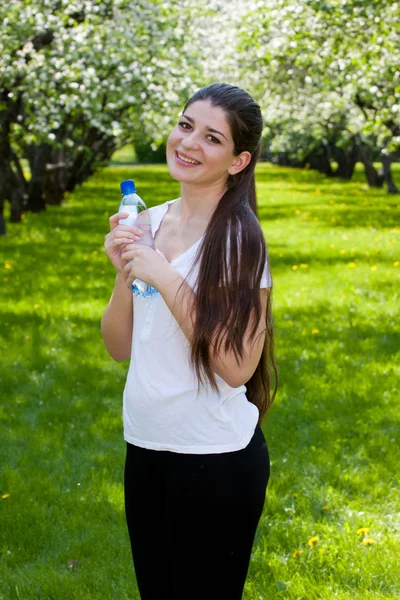 De langharige meisje tegen bloeiende appelbomen. — Stockfoto