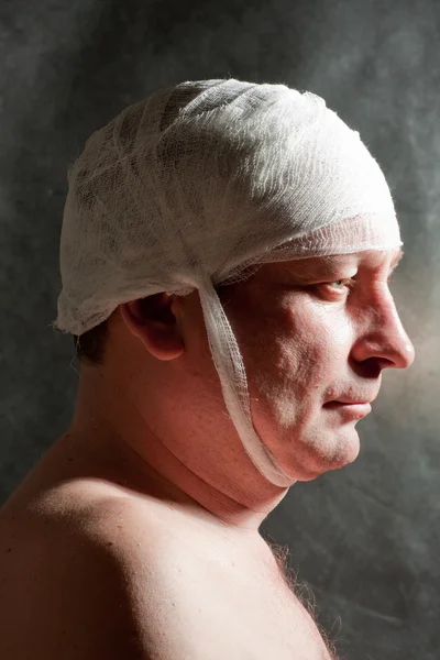 stock image Man with bandage on head. Looking unhappy at something.