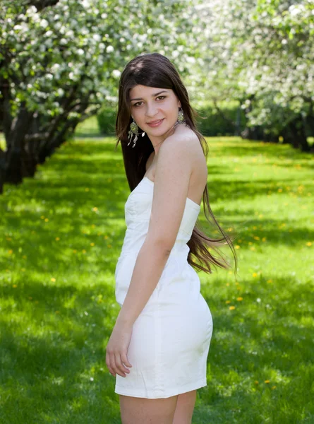 stock image The long-haired girl against blossoming apple-trees.