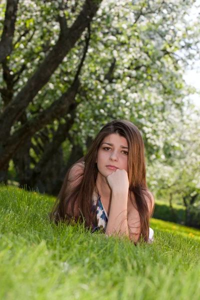 Długowłosy dziewczynę przed kwitnących jabłoni. — Zdjęcie stockowe